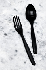 black plastic fork and spoon on grunge background