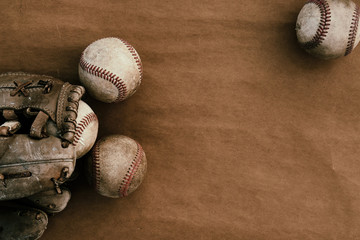 Old leather baseball balls with glove on vintage grunge paper, copy space on background for team sport concept.