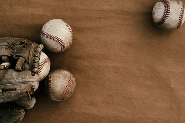 Old leather baseball balls with glove on vintage grunge paper, copy space on background for team sport concept.