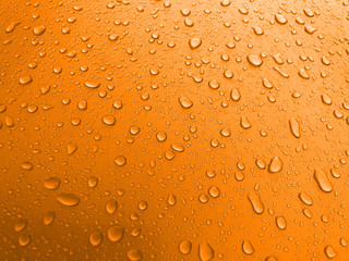 Drops of water on an orange metal surface, beautiful background after rain