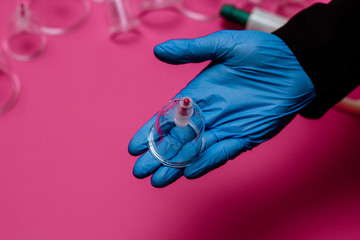 Vacuum pumps and jars for hijama. Arms. On a pink background
