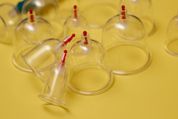 Jars for hijama. Vacuum pumps on a yellow background