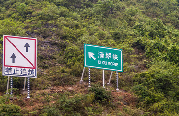 Wuchan, China - May 7, 2010: Dicui or emerald Gorge on Daning River. Boat traffic signs on steep...