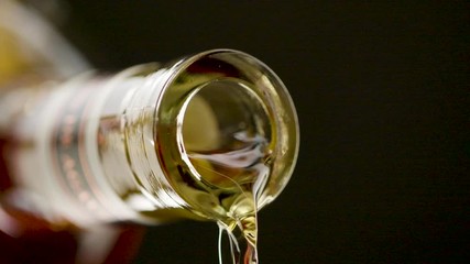 Close up of alcohol pouring out of the mouth of a bottle of alcohol - Powered by Adobe