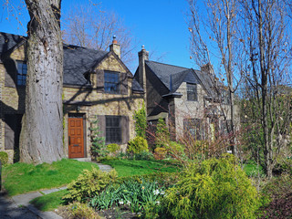 Fototapeta premium Street of older brick detached homes with front yards and large mature trees