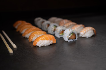 Fresh salmon sushi , salmon maki roll Japanese food restaurant, salmon sushi on plate. Sushi platter with a mixed variety of the Japanese delicacy at a buffet spread table.