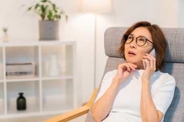 電話をするシニア女性　考える