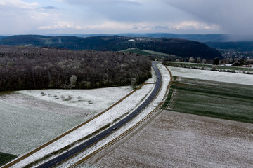 Curvy road crossing agriculture fields covered in snow