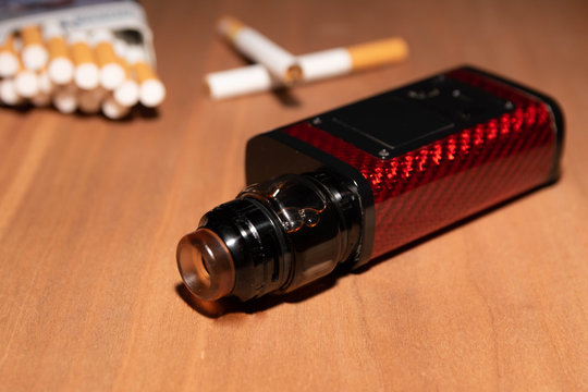 electronic cigarette and cigars on wooden background