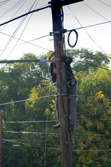 Operator working on telephone pole with chinstrap in times of quarantine, epidemic,