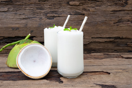 Coconut smoothie drink white fresh cocktail shake milkshake vanilla juice fruit beverage food healthy the taste yummy In glass on wooden background.