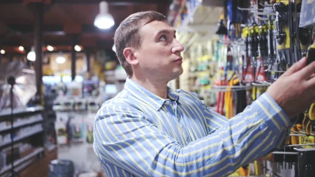 Male customer choose locksmith tools at hardware store