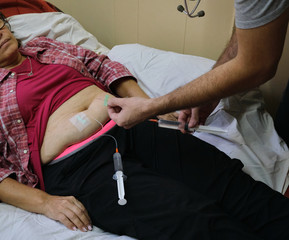 a physician doing a subcutaneous vial for the treatment of an adult woman with covid-19 during the pandemic