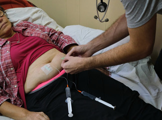 a physician doing a subcutaneous vial for the treatment of an adult woman with covid-19 during the pandemic