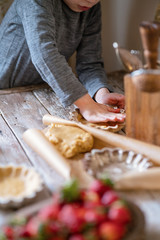 homemade tartlets with berry curd and strawberries. A little boy Baker makes tartlets for his mom on Mothers day. Home cooking, children's education concept