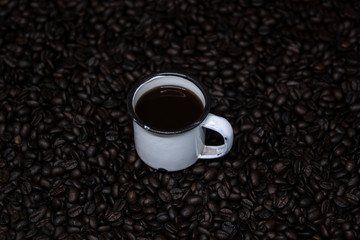 Mug with coffee over coffee beans