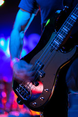 Obraz na płótnie Canvas A closeup of a guitarist strumming an electric guitar on stage during a rock music performance at a venue on 6th Street in Austin, Texas. 