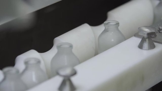 glass bottles on medical solution conveyor line close up selective focus medical industry