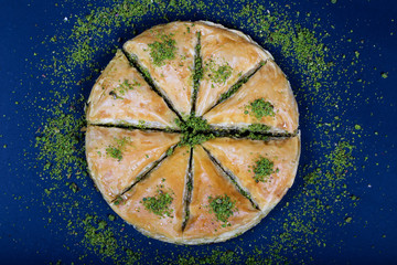Obraz na płótnie Canvas circle Baklava slices Turkish ramadan Dessert with blue background