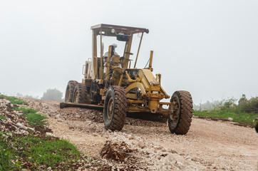 Fototapeta premium Grader At Work On Foggy Day