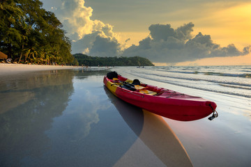 Red kayaks are at the beach by the sea in the evening at Ko Kood, Thailand, in the summer holiday concept.