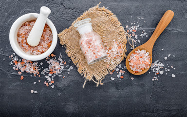  Himalayan pink salt on dark concrete background. Himalayan salt commonly used in cooking and for...