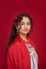 adolecente mexicana latina con blusa bordada en fondo rojo con flores de regalo y bordados hechos a mano