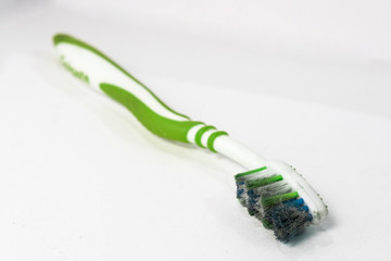 An old and dirty green toothbrush used to clean dirty surfaces. Reused and repurposed as general...