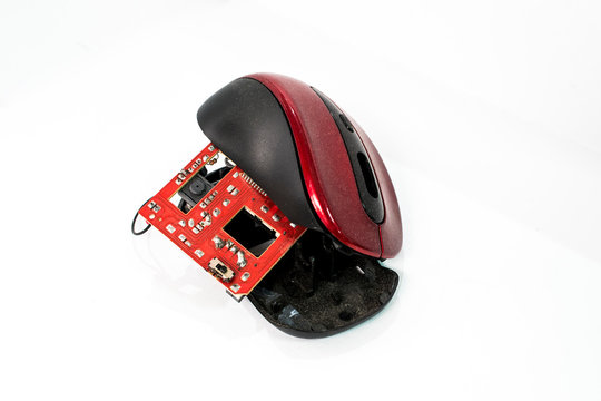 A Disassembled Or Broken Red Computer Mouse On A Plain Background