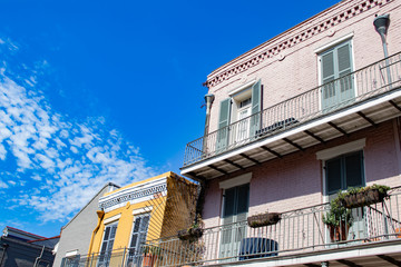 Fototapeta na wymiar Bright Blue Sky with Clouds Peeks from behind Traditional Colonial Buildings in the French Quarter of New Orleans, Louisiana, USA