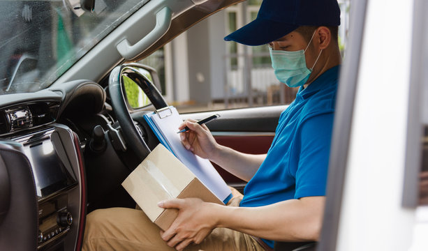 Asian delivery courier young man driver inside the van car with parcel post boxes checking amount he protective face mask, under curfew quarantine pandemic coronavirus COVID-19