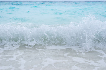 Sea waves splashing on the white beach