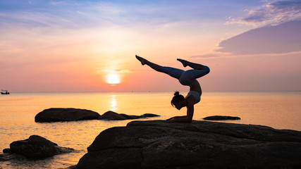Asian girl practice Yoga on the beach Sunrise morning day