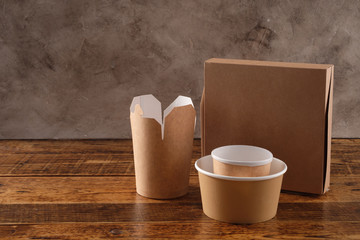 Street fast food paper cups, plates and containers. Eco-friendly food packaging on wooden background. Carering of nature and recycling concept.