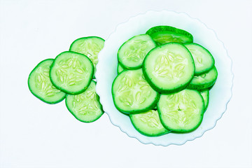 Slices of fresh green cucumber in a ceramic bowl.