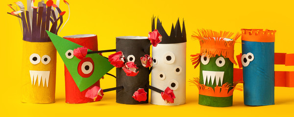 Fototapeta premium Kids art therapy, coronavirus pandemic. Halloween crafts, paper monsters on blue paper background with copy space for text. Concept handcraft, diy, creative idea from toilet tube, recycle