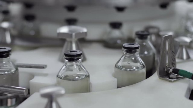 glass bottles on a medical solution conveyor at filling station close up medical industry