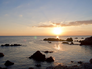 Obraz na płótnie Canvas Sunset sky and silhouette rock beach landscape