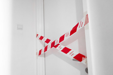The entrance to the apartment is blocked by a protective tape. Crime scene. Do not enter