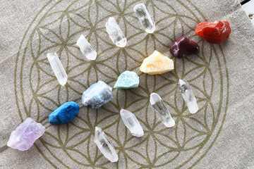A close up image of chakra balancing crystals on a sacred geometry grid cloth.  - obrazy, fototapety, plakaty