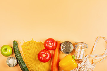 Donation bag with various food on orange background with copy space. Flat lay. top view, Mockup. Food donations or food delivery service concept. Online shopping during coronavirus covid-19 lockdown