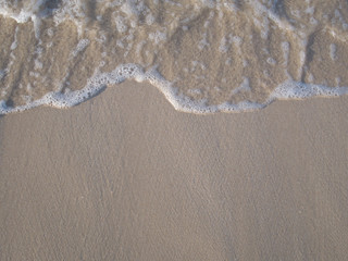 White sea wave on the sand beach