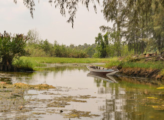 Fototapeta na wymiar Small wooden boat in the peaceful canal 
