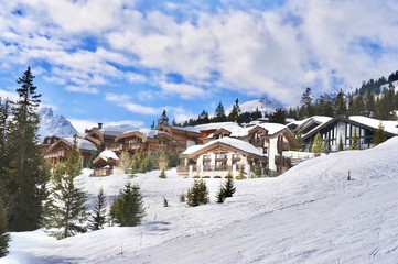 Courchevel ski resort in winter with it’s beautiful wooden chalets next to the ski slope.