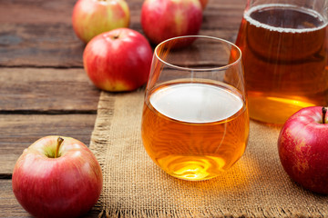 Fresh organic glass of apple juice and red apples.