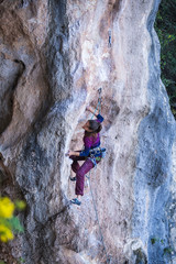 A strong woman climbs a rock, Rock climbing in Turkey.