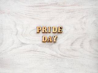 Happy Pride Day. Rainbow Flag lying on an empty table. Beautiful card. Isolated background, wooden surface. Congratulations for relatives, friends and colleagues
