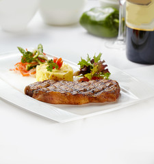 Steak with mashed potatoes and salad.