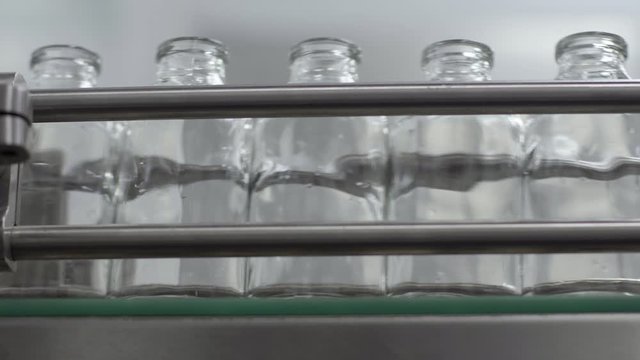 glass bottles on medical solution conveyor line close up medical industry