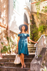 Young and beautiful brunette girl in dress and hat walking outdoor in the street. Nice, France. Summer vacation, traveling and tourism. - 345039191